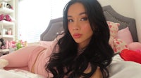 a girl laying on a bed with a teddy bear